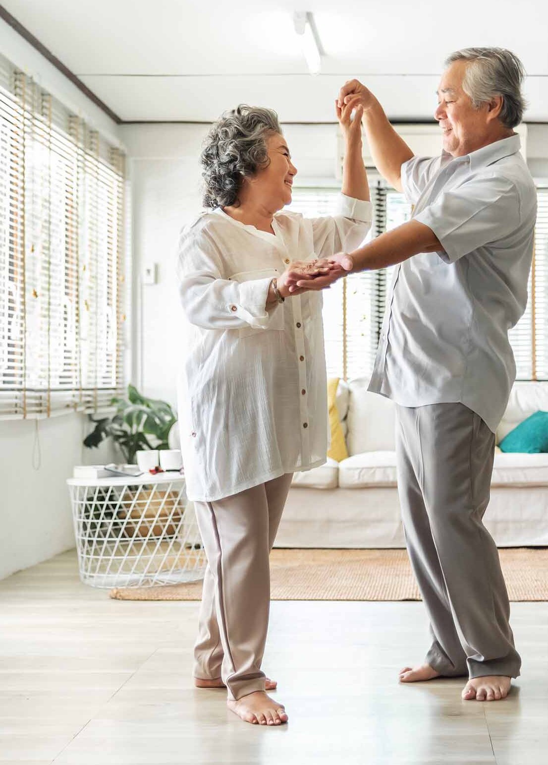 Romantic Asian Senior couple dancing at home. Happy Smiling Grandfather and Grandmother having fun Celebrating in wedding Anniversary day. Elderly man and woman holding hands together, Romance, lover